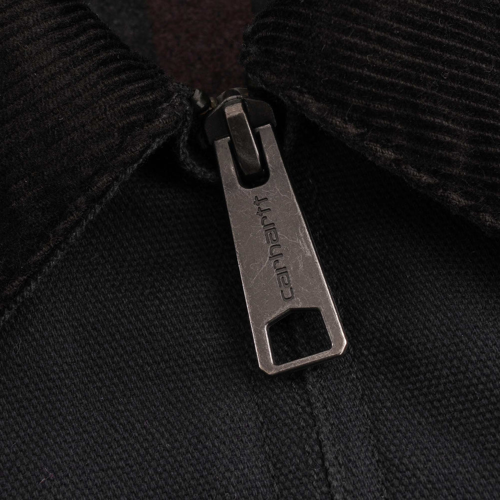 A close-up of the Carhartt-branded zip pull on a black jacket.