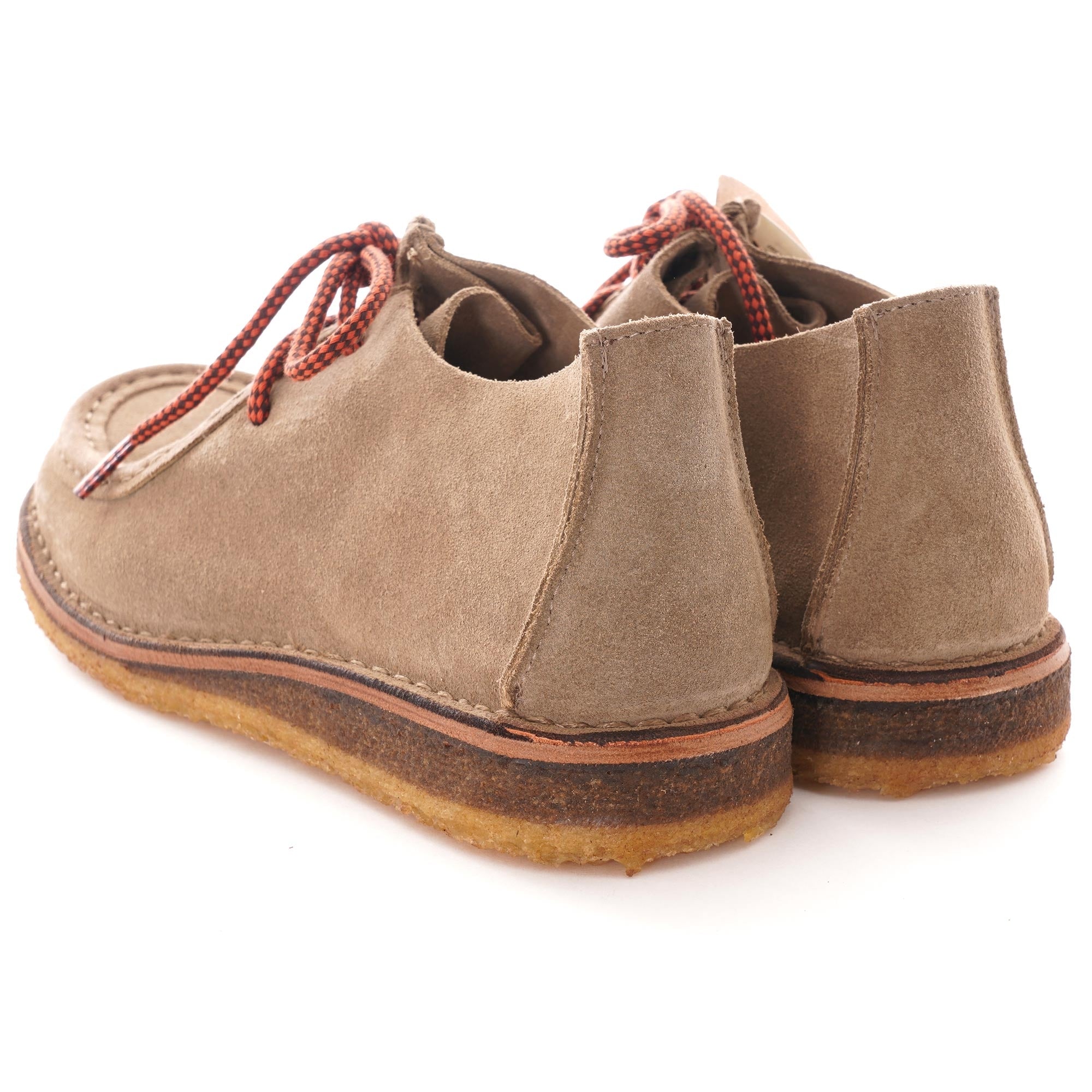 A pair of taupe suede shoes with red and black laces, viewed from the back.