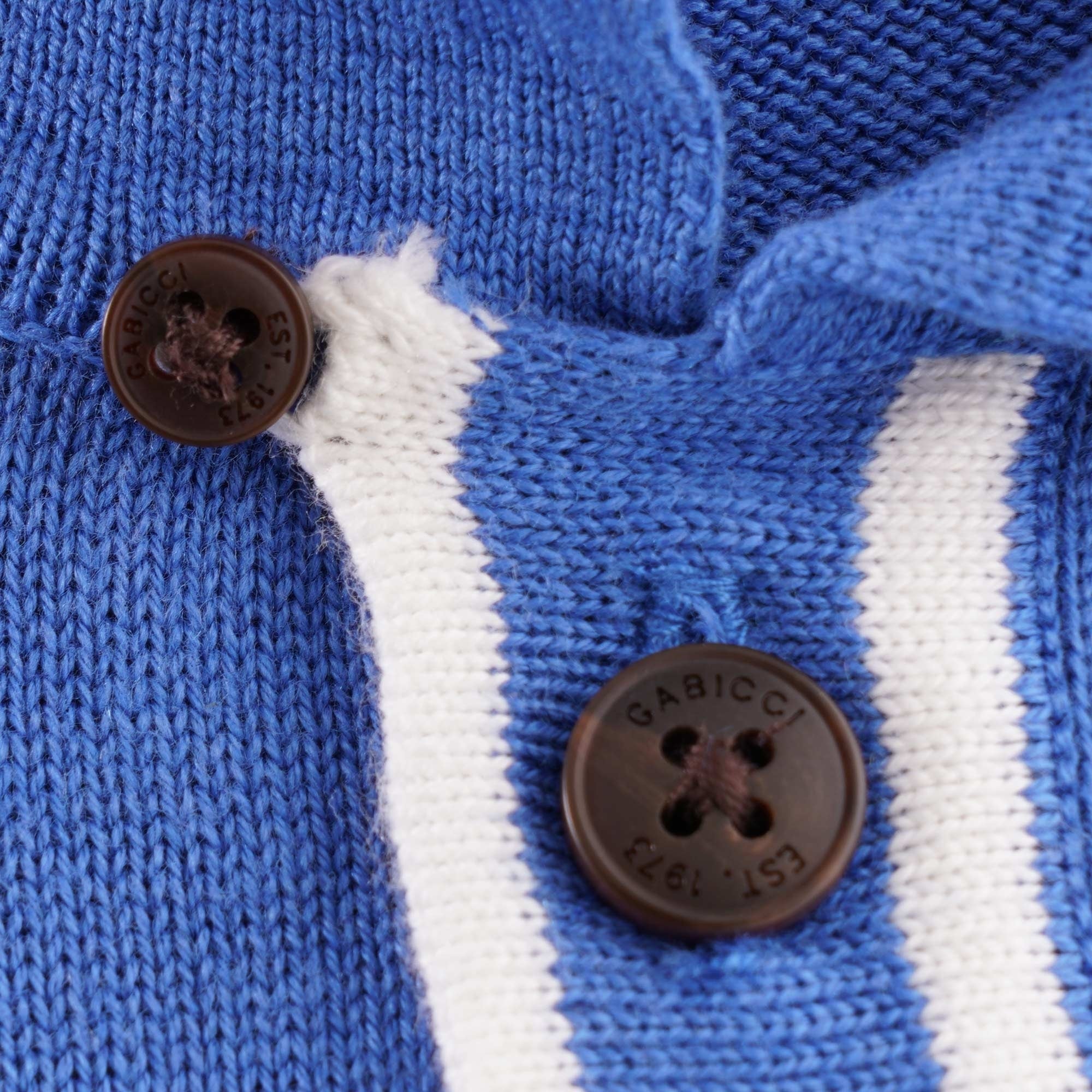 Detailed view of the placket with two brown buttons and white stripe detailing.