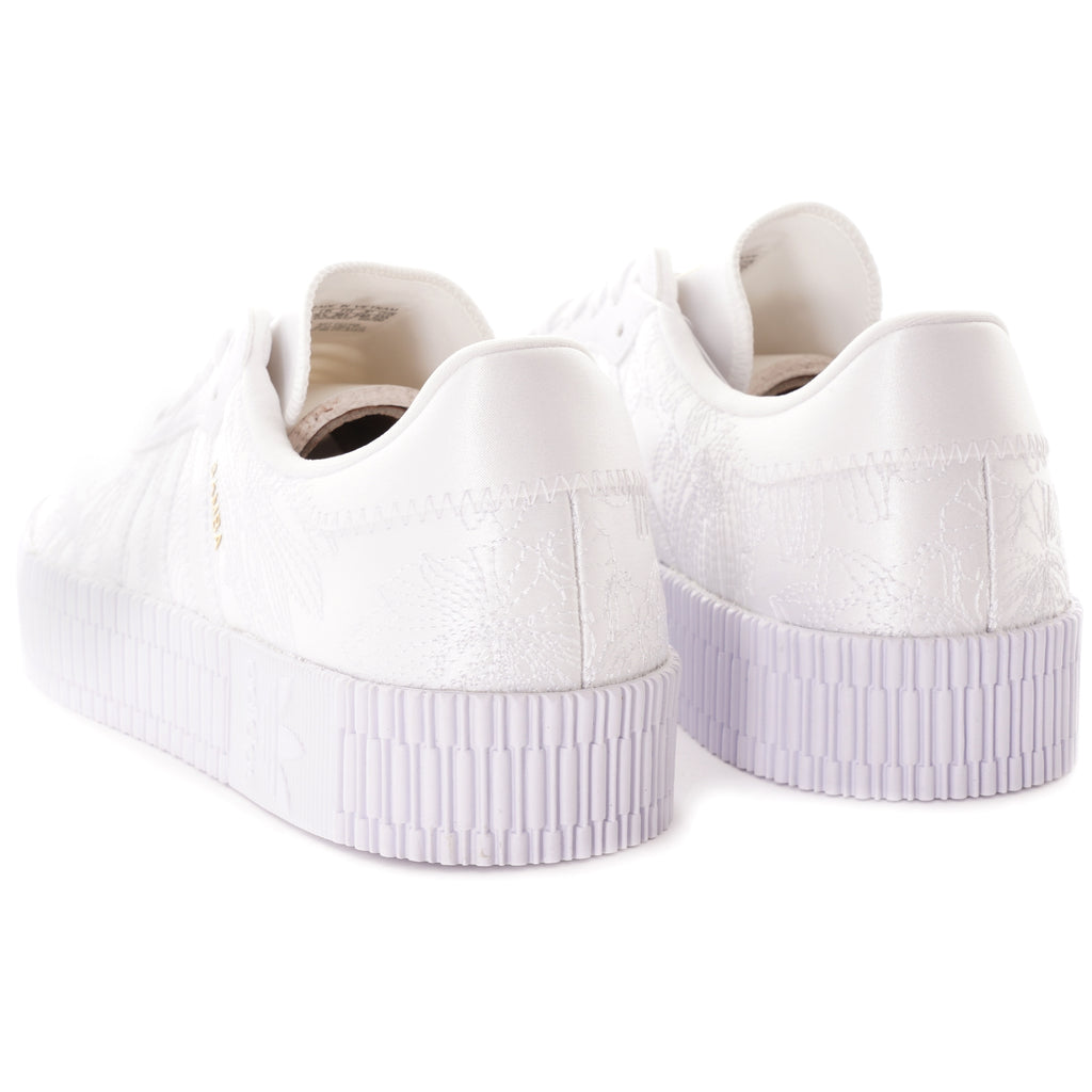 A pair of white Adidas Sambarose trainers, rear-angled view, on a white background.
