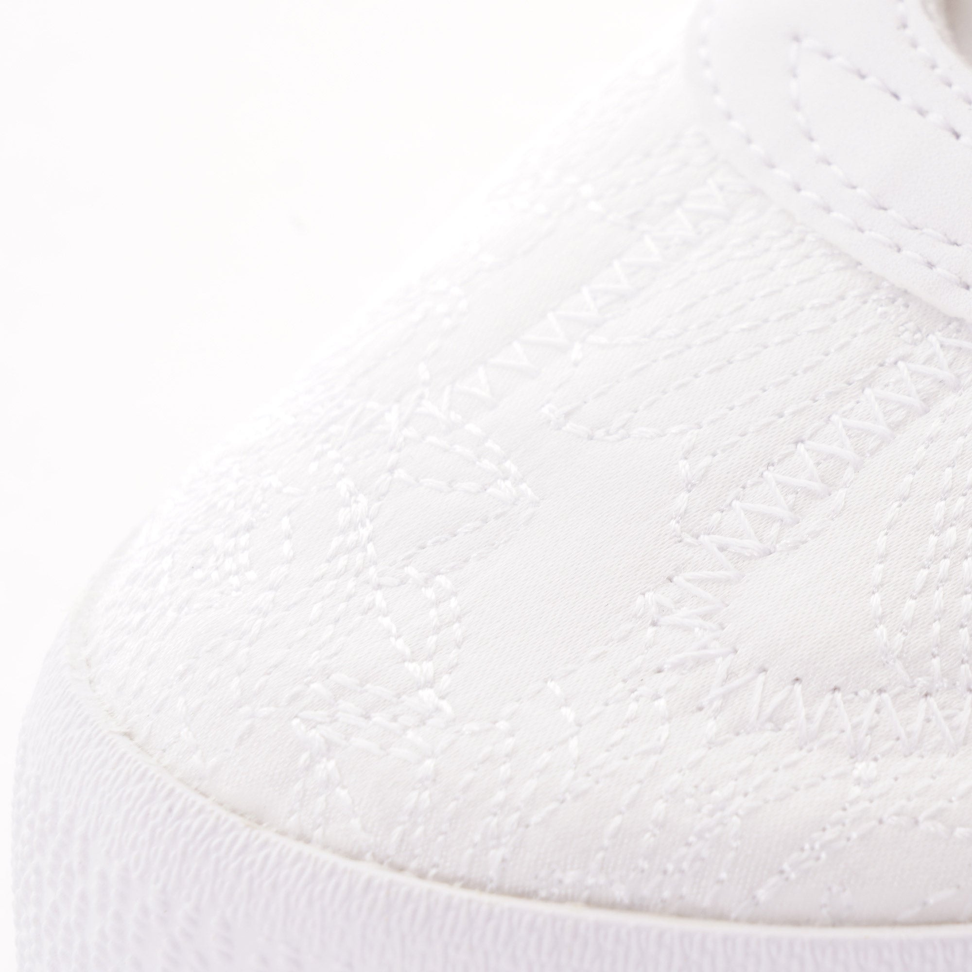 Close-up of the textured toe of a white Adidas Sambarose trainer.
