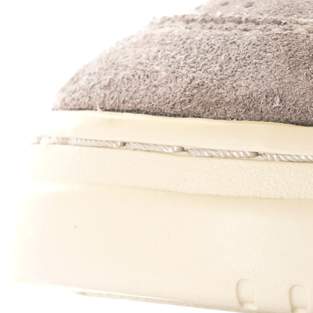 A close-up of the grey suede and white sole of an Autry Medalist Low sneaker.