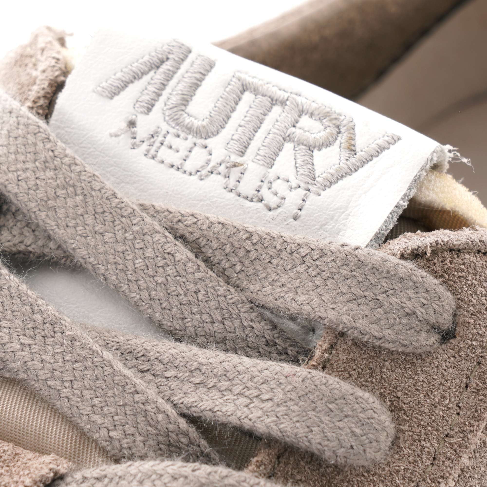 A close-up of the Autry Medalist logo on the tongue of the grey sneaker.