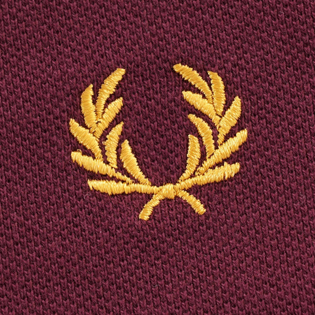Close-up of the Fred Perry gold laurel wreath embroidery on the t-shirt.