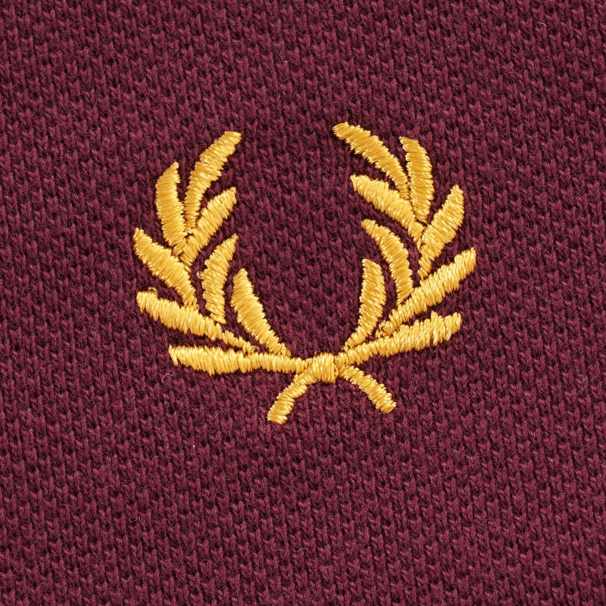Close-up of the Fred Perry gold laurel wreath embroidery on the t-shirt.