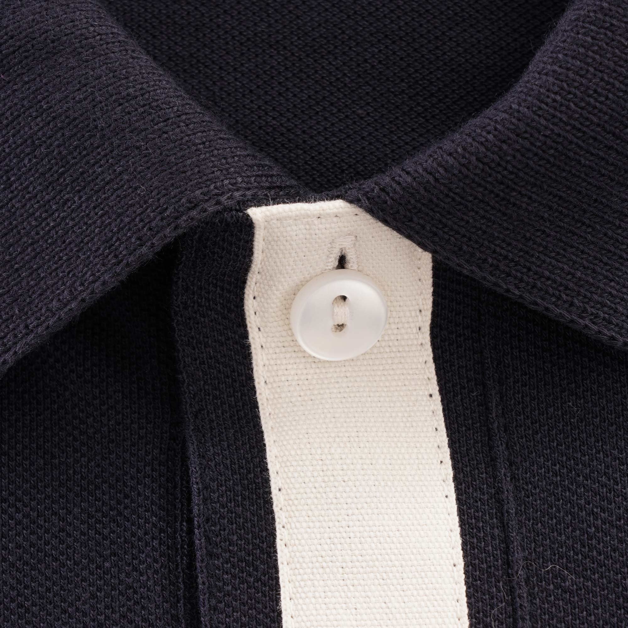 A close-up of the top button and collar of the Fred Perry knitted shirt.