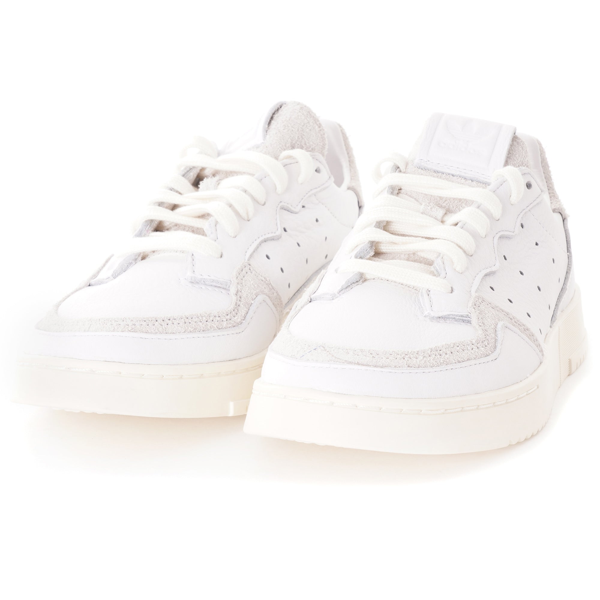 A pair of white adidas Supercourt sneakers, showing the front with laces.