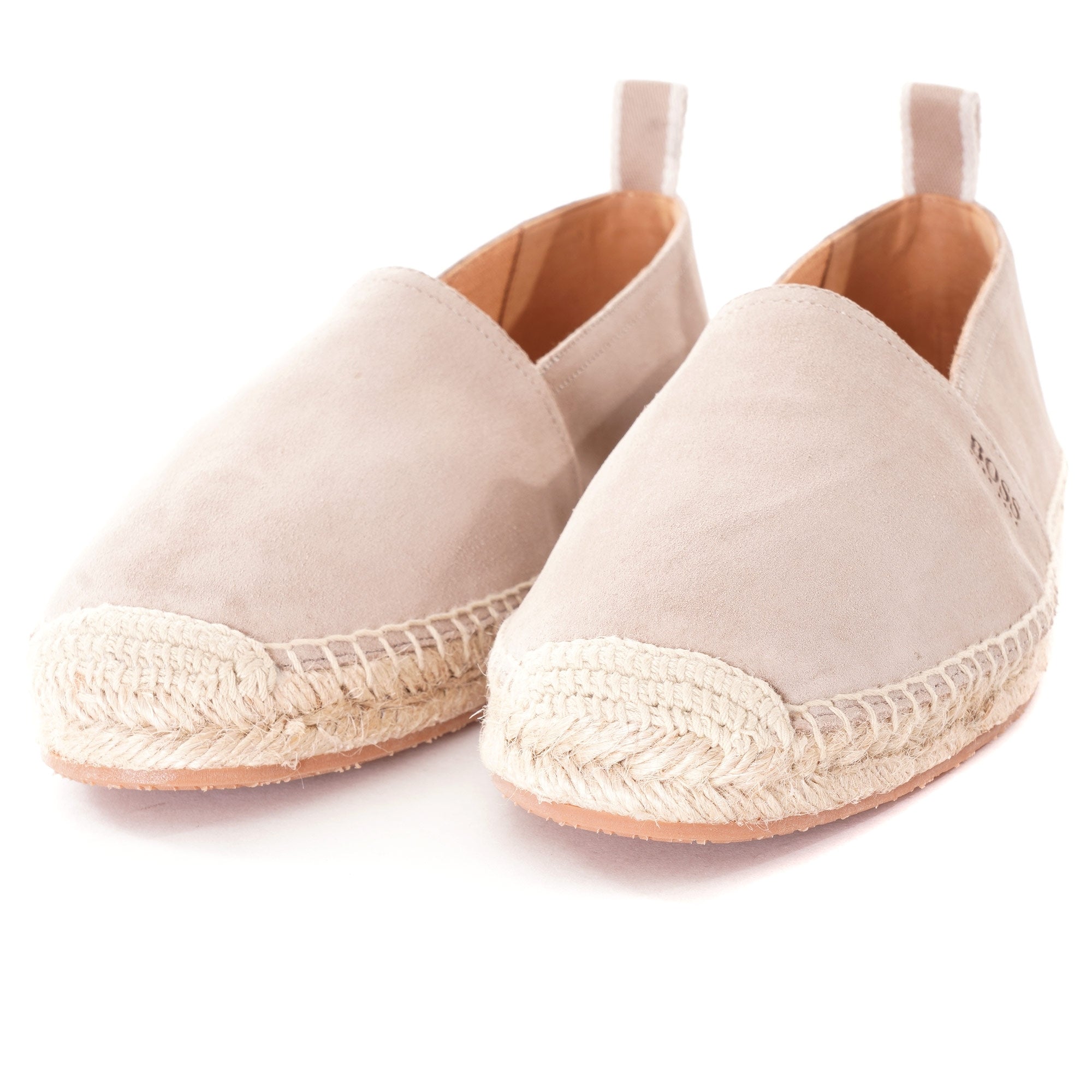 Pair of light beige suede espadrilles with braided jute soles, viewed from an angle.