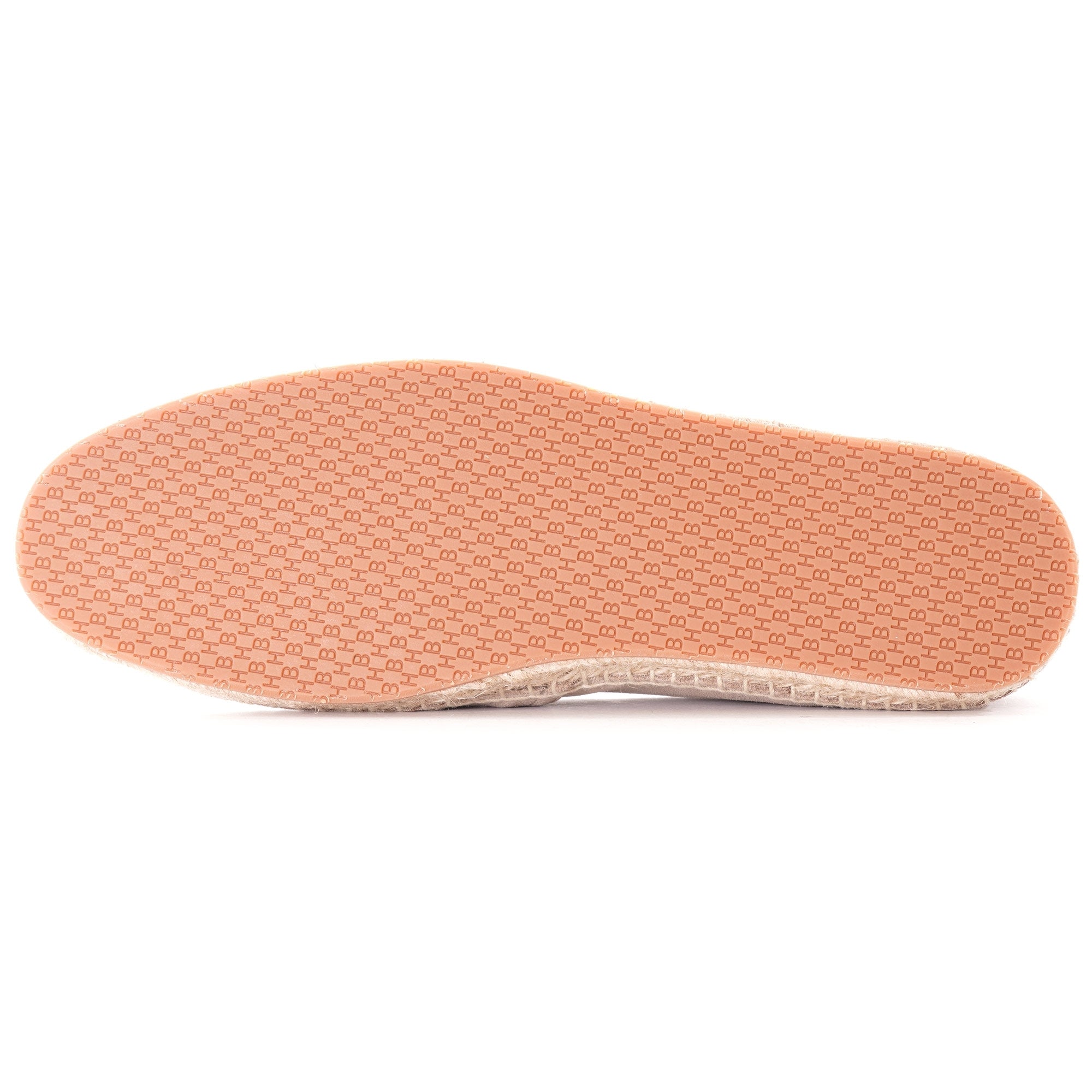 Underside of a light beige espadrille, revealing a textured peach-coloured rubber sole.