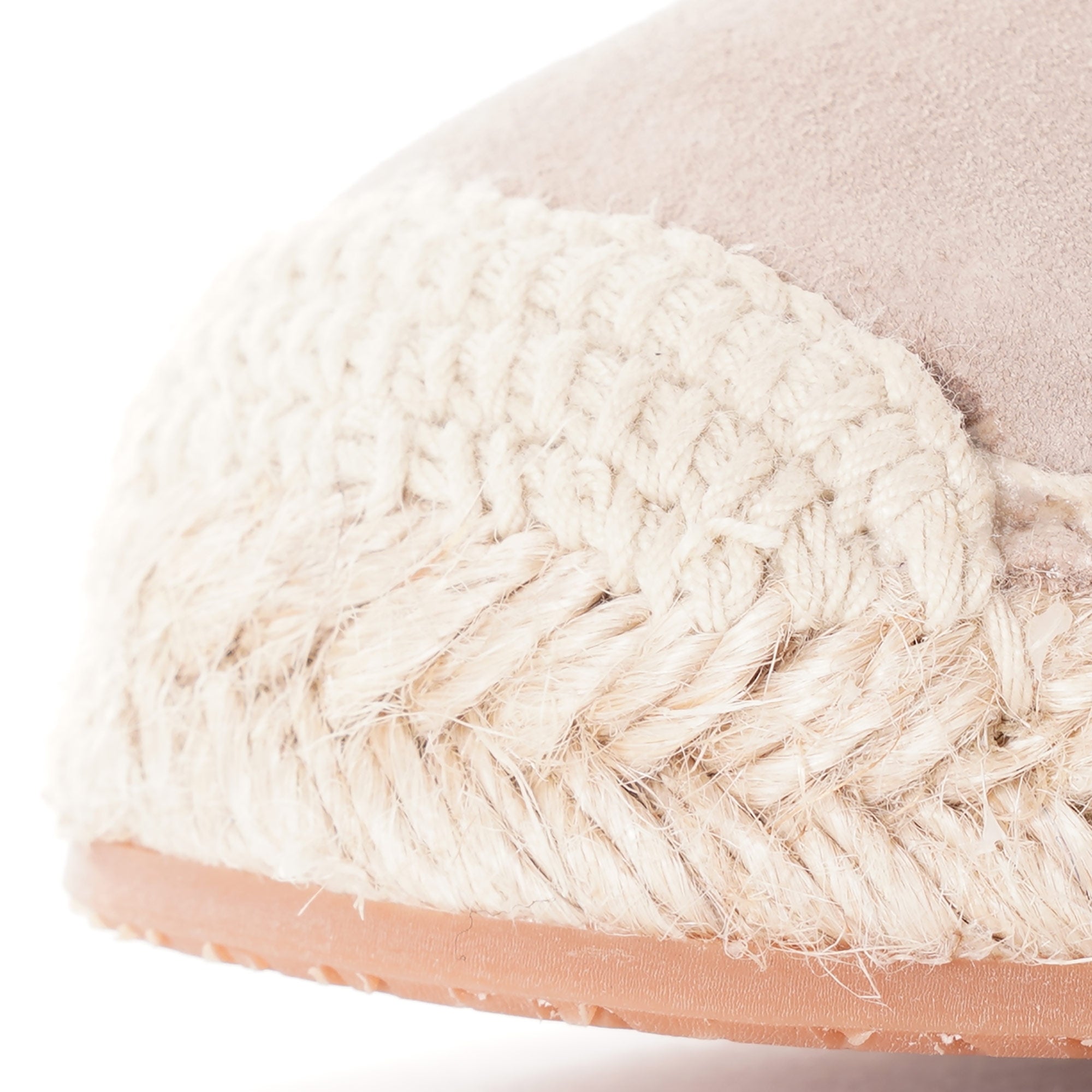 Close-up of the toe of a light beige espadrille, highlighting the braided jute detailing.