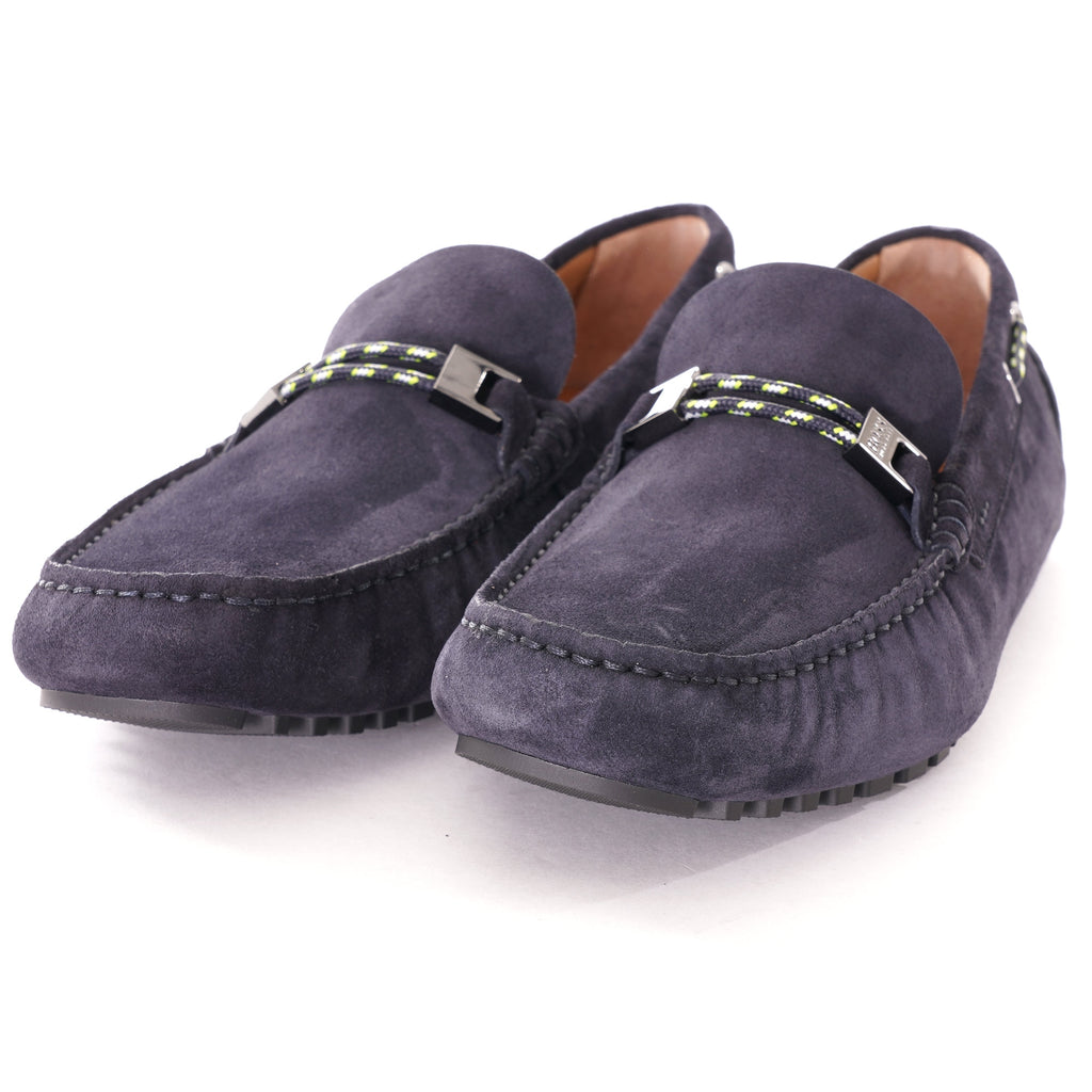 A pair of dark blue suede loafers with metallic buckles and striped detailing.