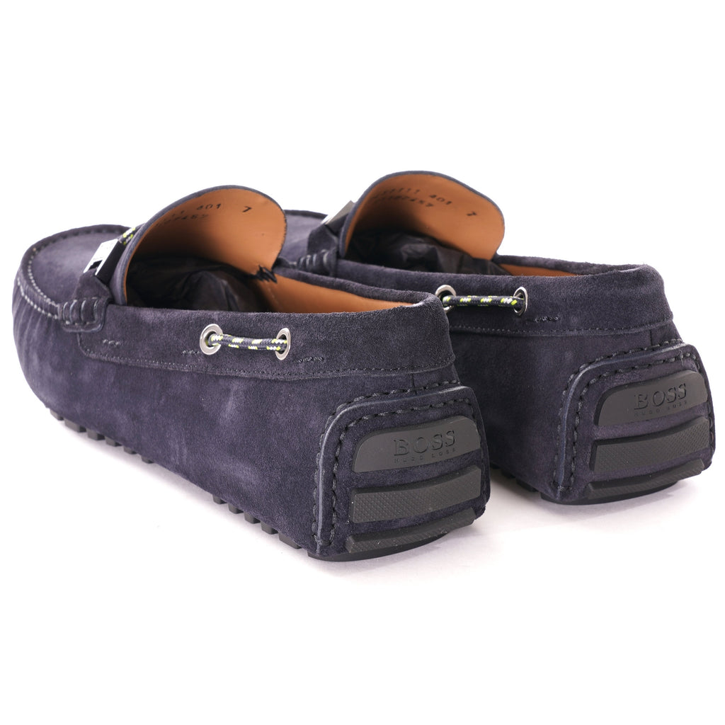 A rear view of the dark blue suede loafers, showing the textured rubber soles.