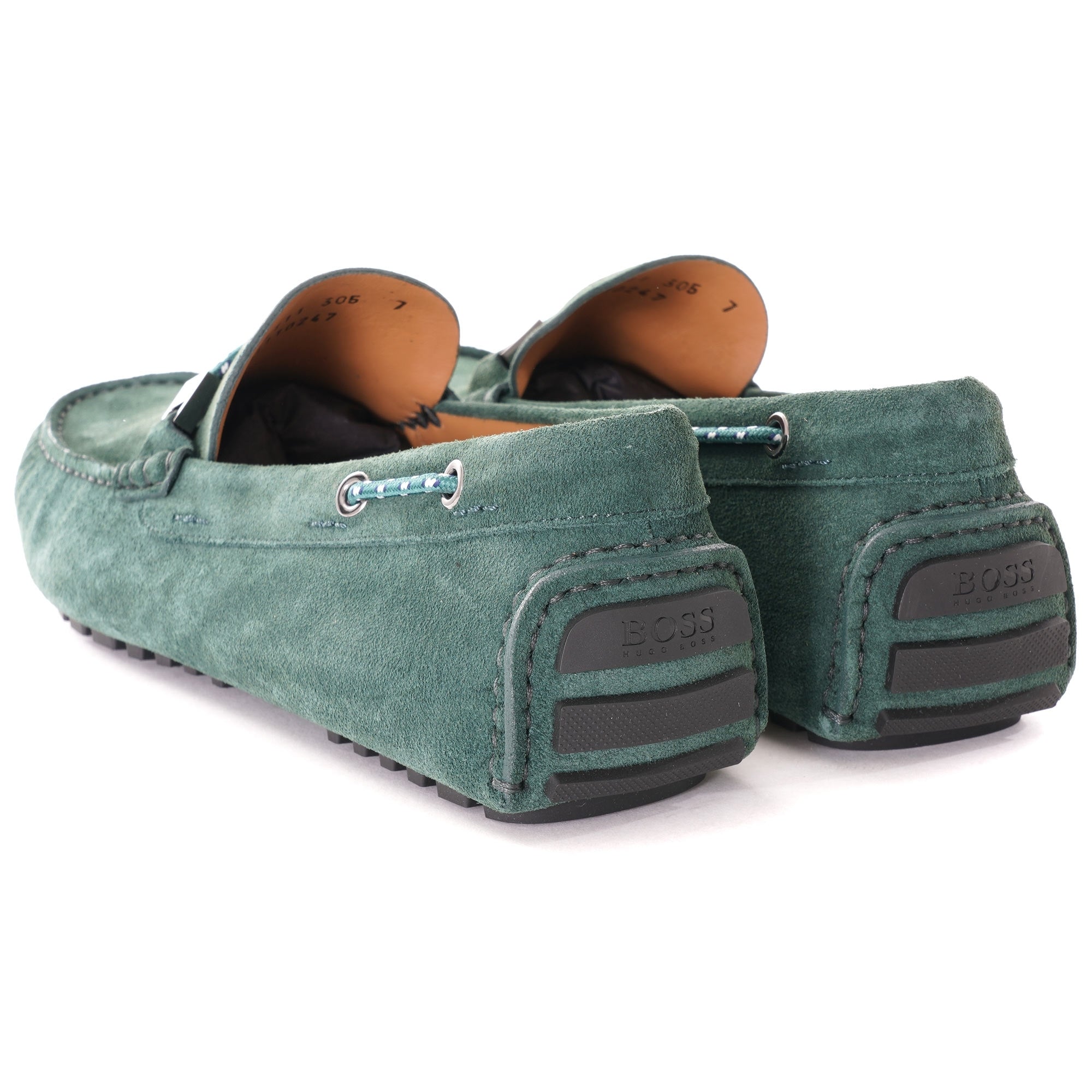Rear view of green suede loafers, highlighting the textured rubber soles.
