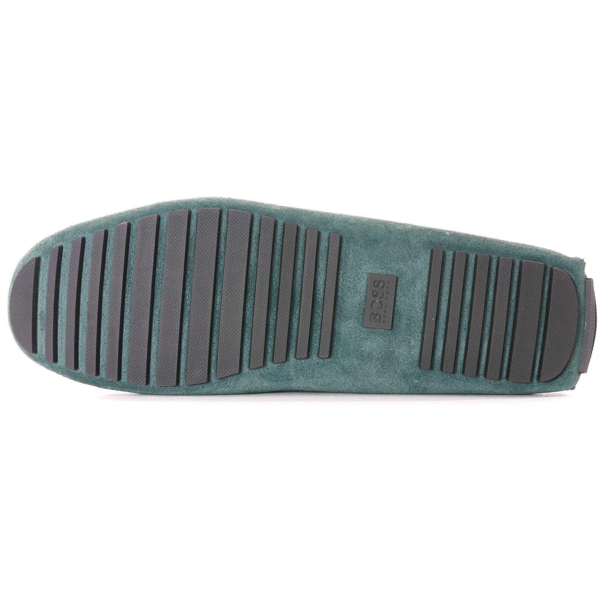 Underside of a green suede loafer, showcasing the black rubber sole pattern.