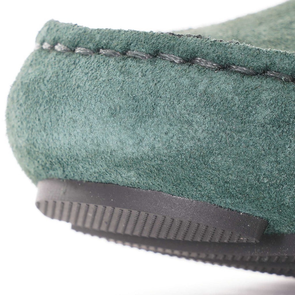 Close-up of the heel of a green suede loafer, showing the stitching and sole.