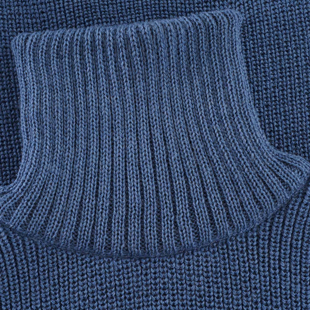 Close-up of the ribbed roll neck collar of the blue jumper.