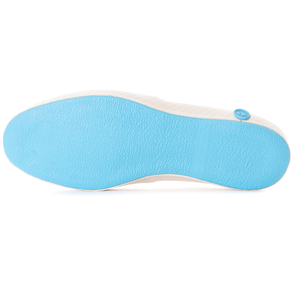 The sole of a white slip-on canvas shoe, in light blue, is shown from below.