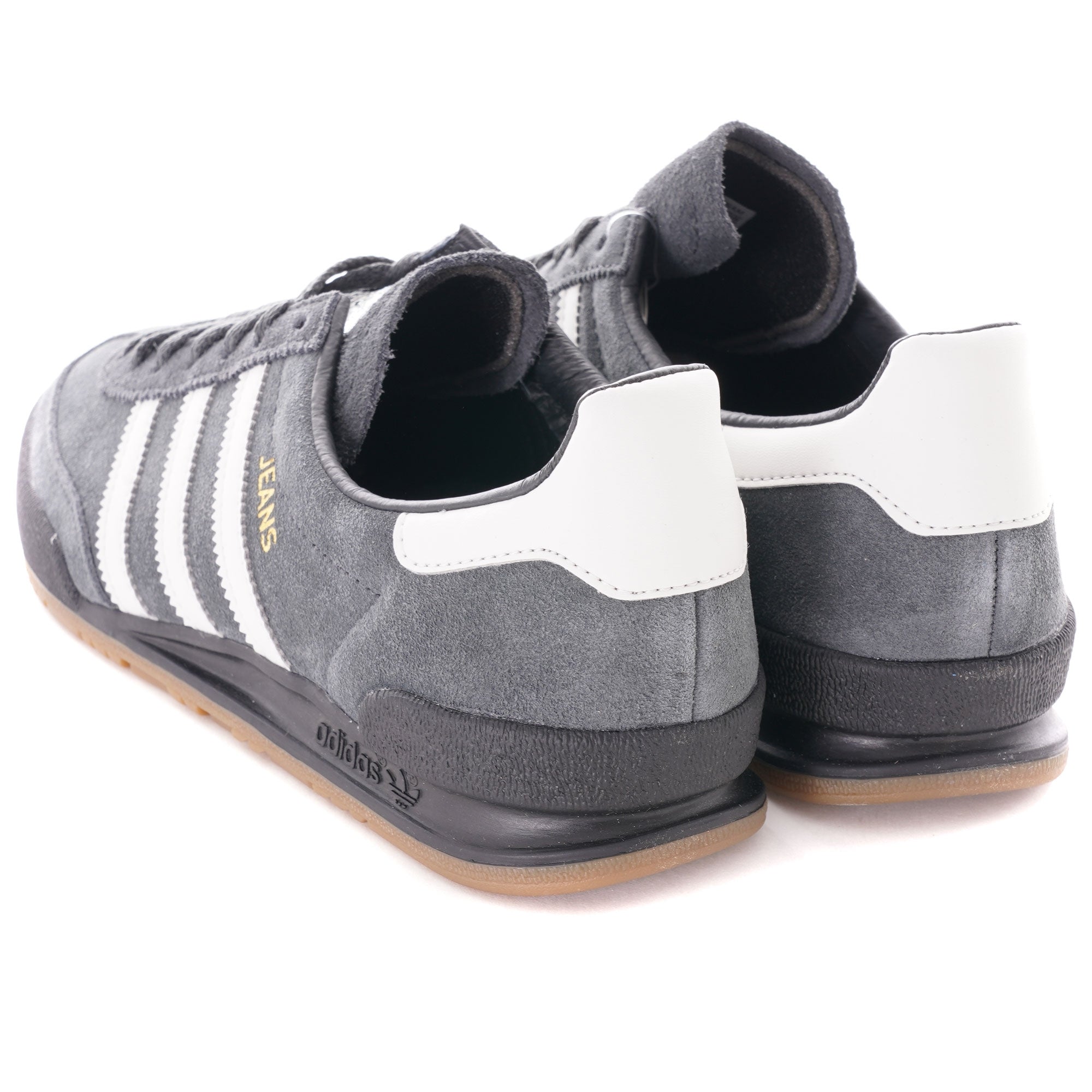 A pair of grey Adidas Jeans trainers, viewed from the rear, showing white heel accents.
