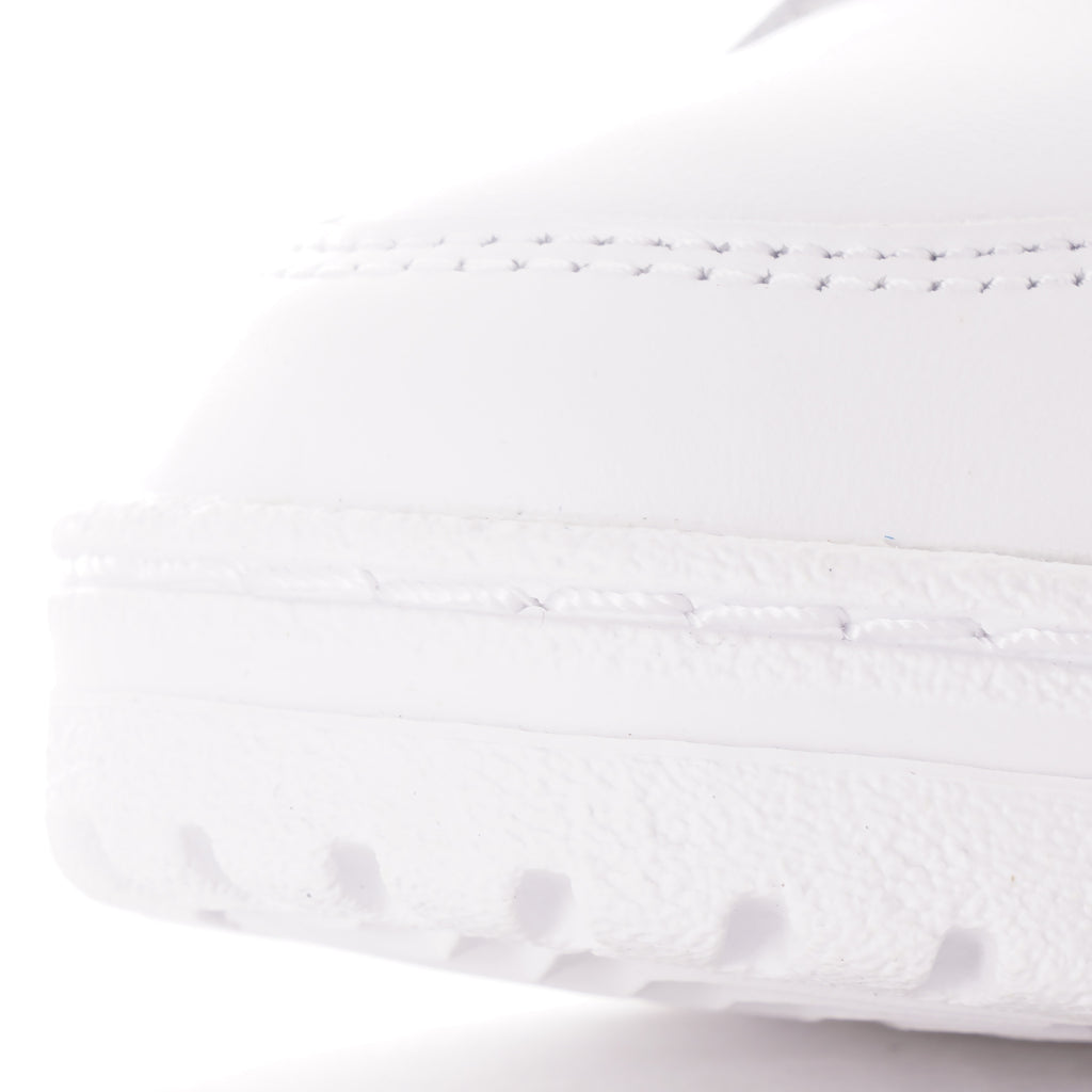 Close-up of the textured toe area of a white Adidas trainer.
