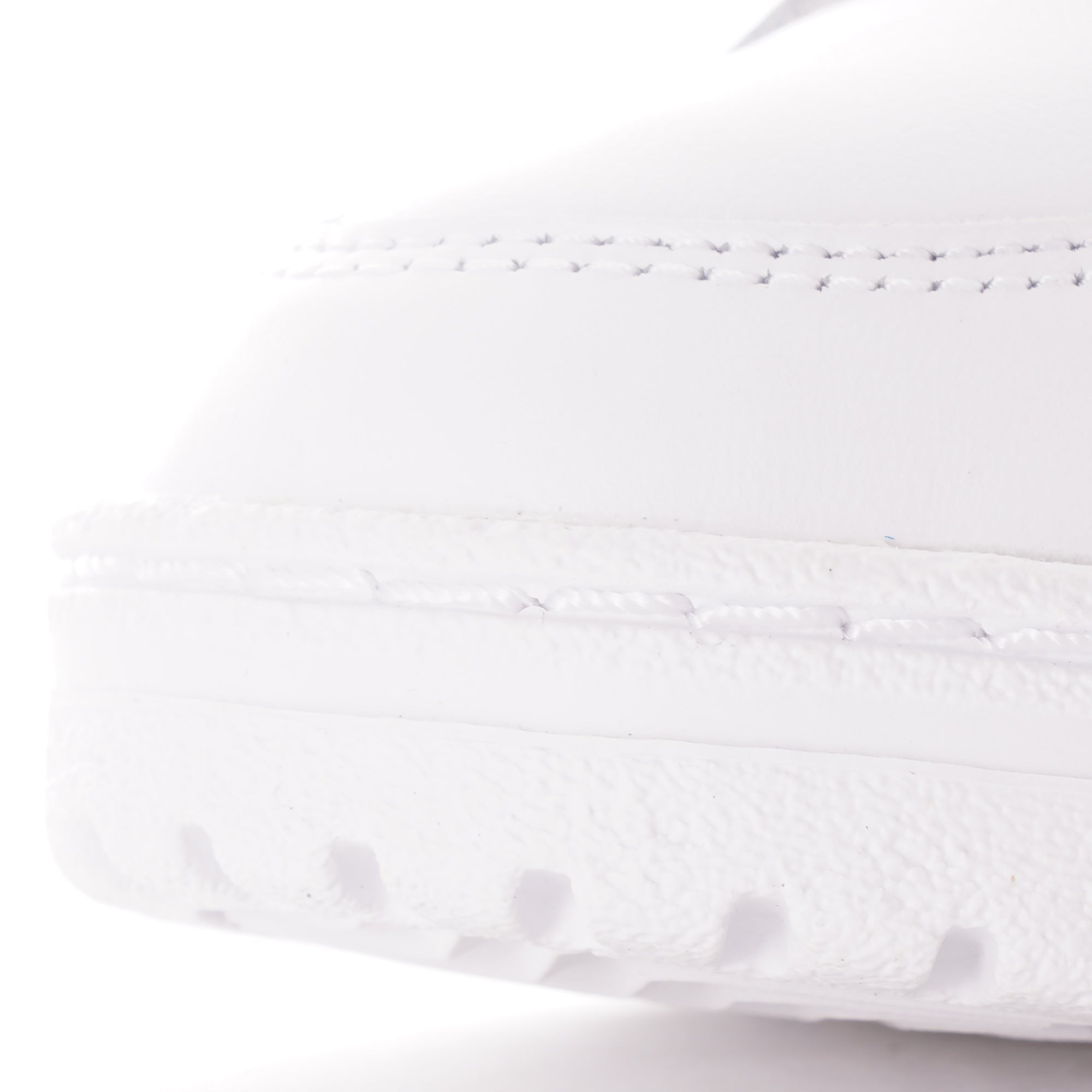 Close-up of the textured toe area of a white Adidas trainer.