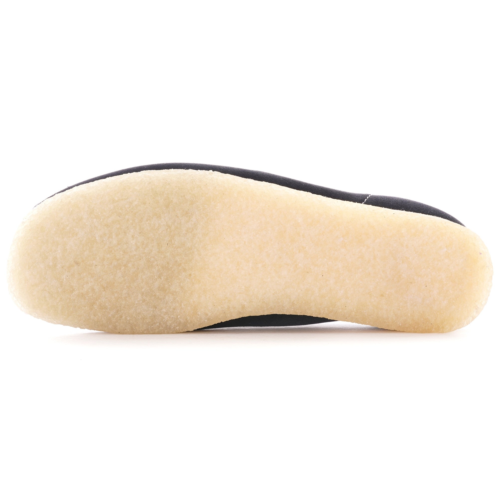 The light brown crepe sole of a dark blue suede shoe, top down view.