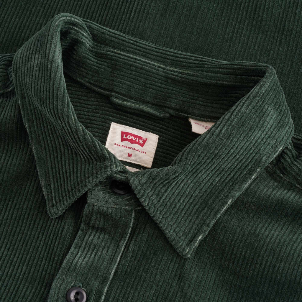 Close-up of the collar and Levi's label on a green corduroy shirt.