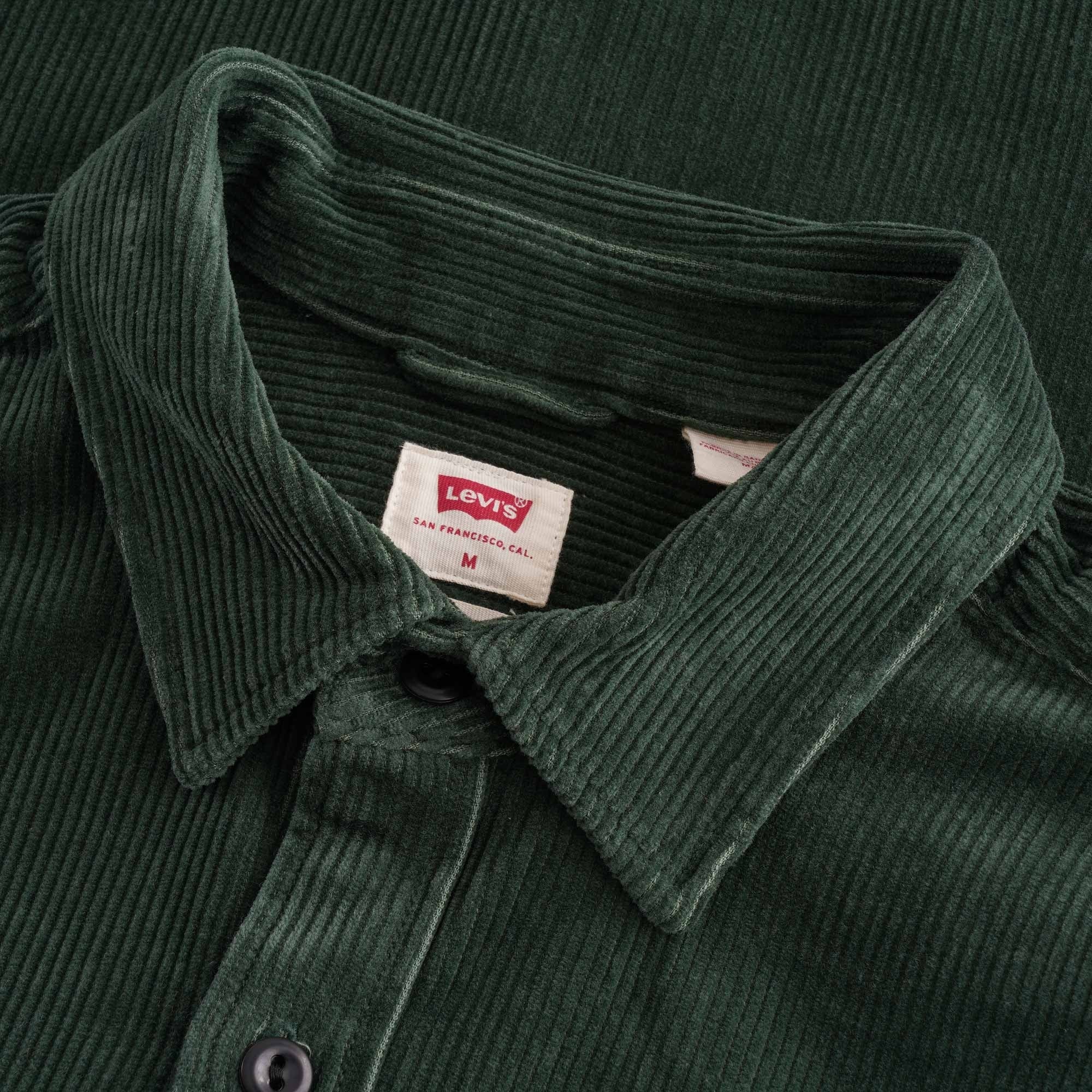Close-up of the collar and Levi's label on a green corduroy shirt.