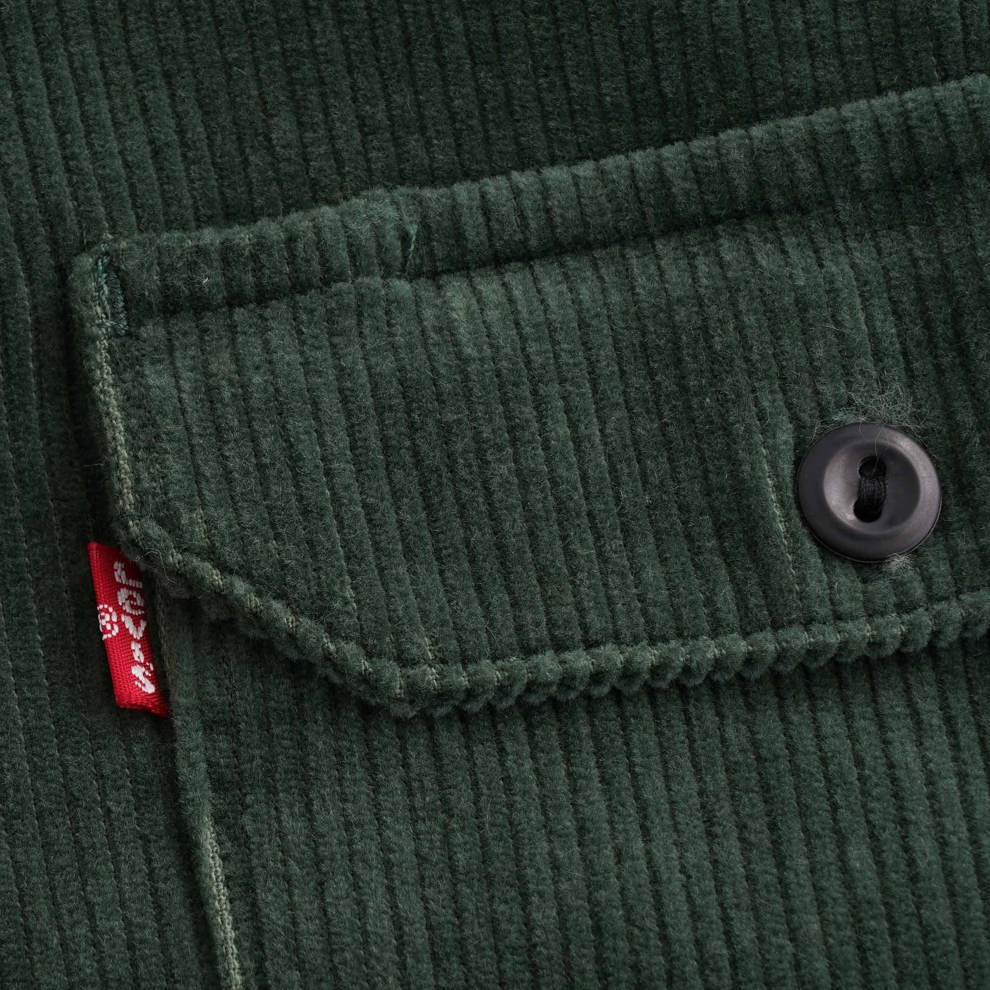 Close-up of the chest pocket and Levi's red tab on a green corduroy shirt.