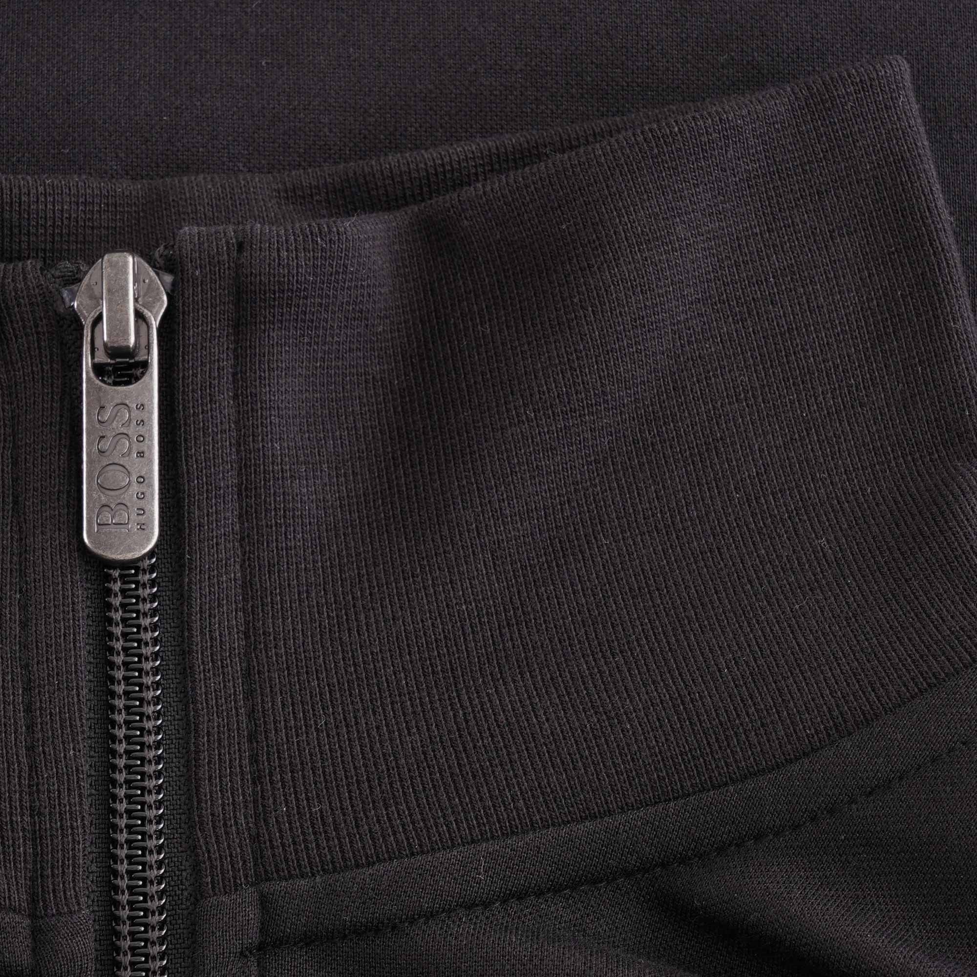 Close-up of the black ribbed collar and silver BOSS branded zip pull of the track jacket.