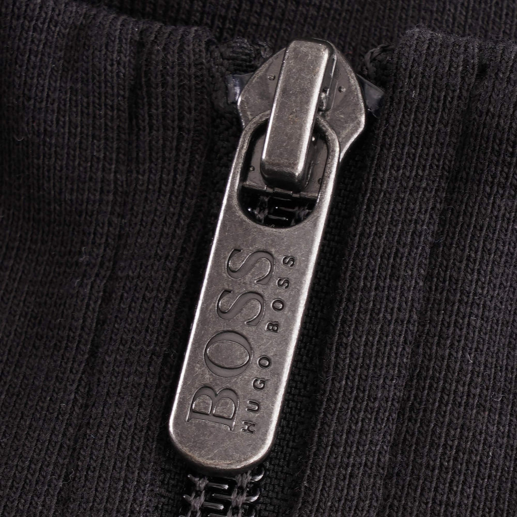 A close-up of the silver BOSS Hugo Boss branded zip pull on the black track jacket.