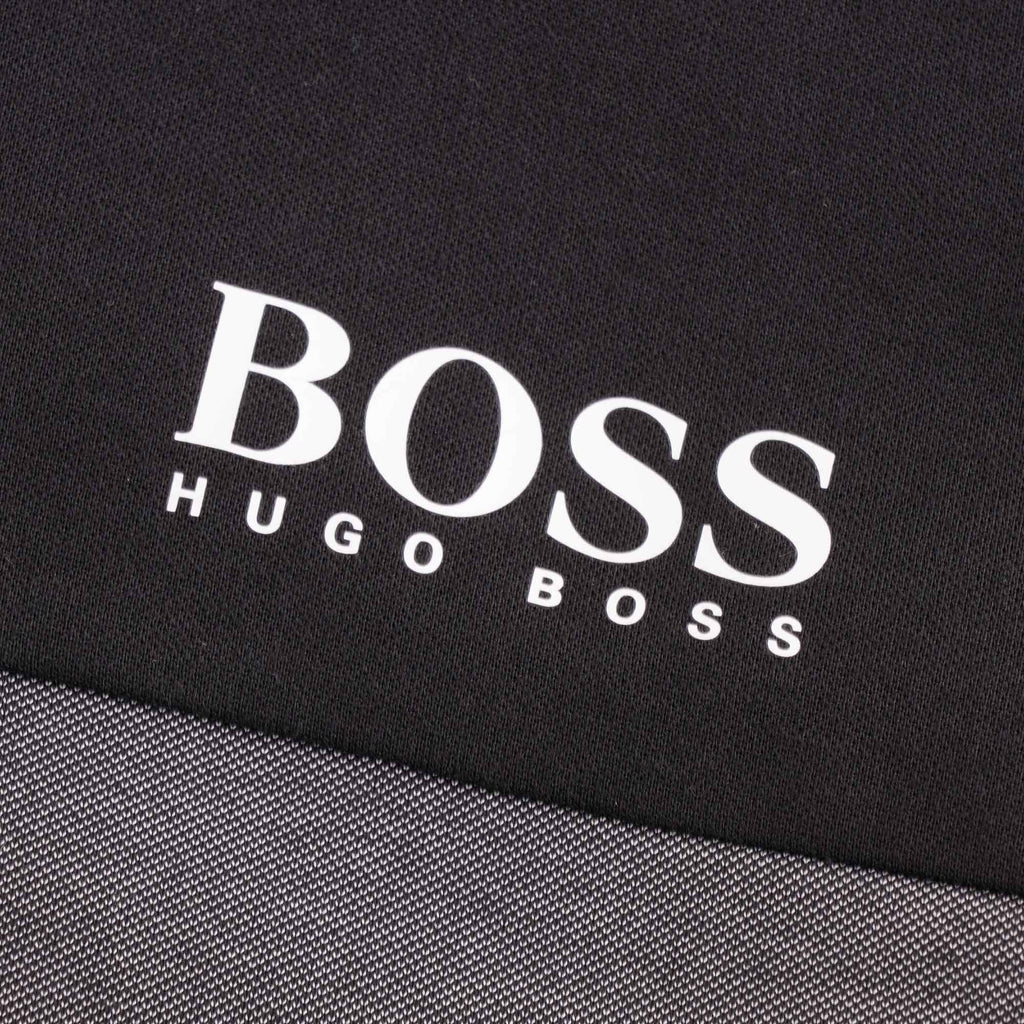 Detail of the white BOSS Hugo Boss logo printed on the upper left chest of the track jacket.