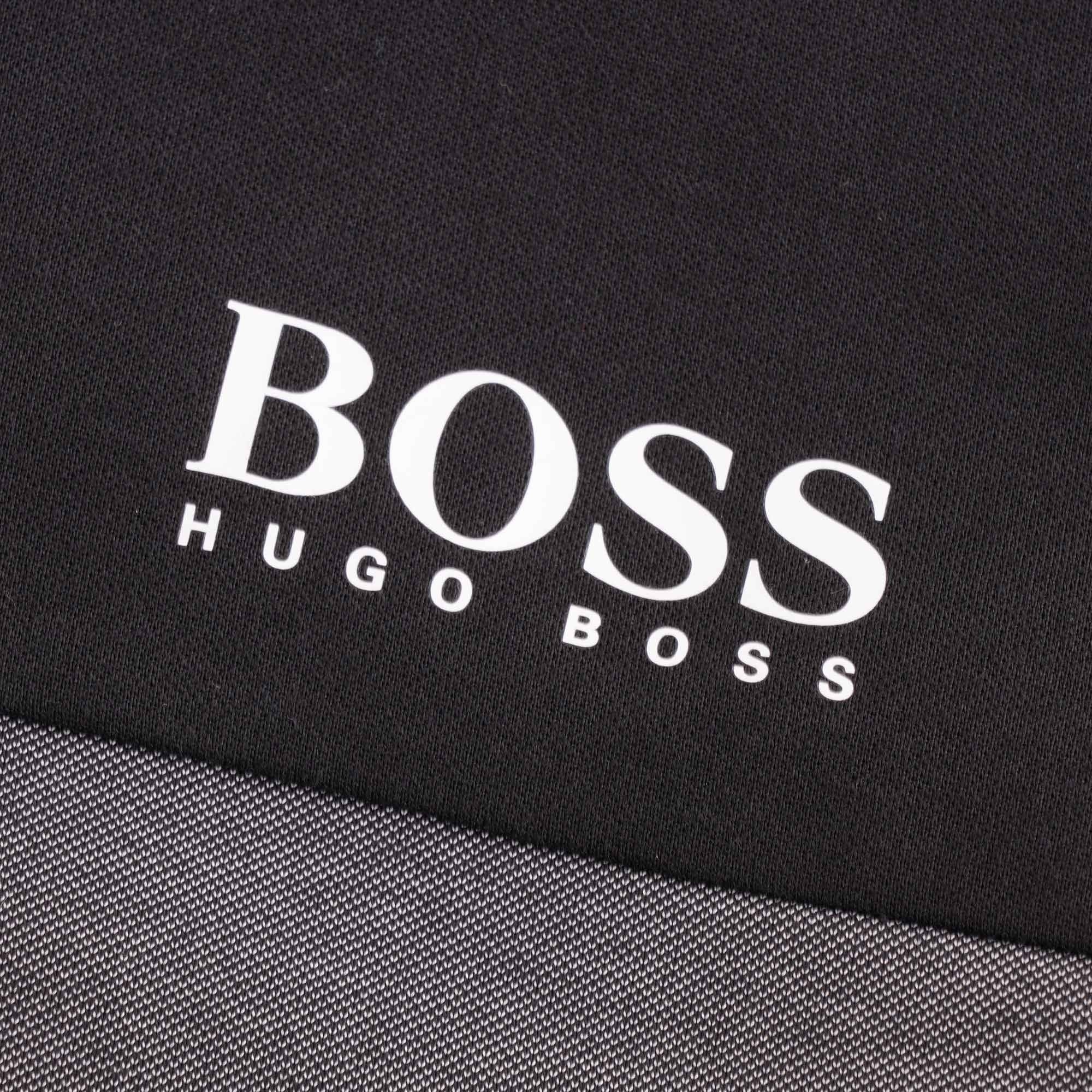 Detail of the white BOSS Hugo Boss logo printed on the upper left chest of the track jacket.