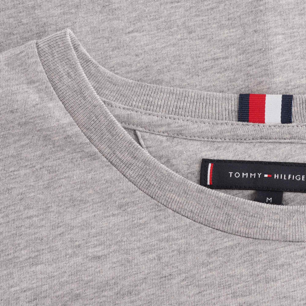 A close-up of the collar area of a grey Tommy Hilfiger t-shirt, showing the branding.