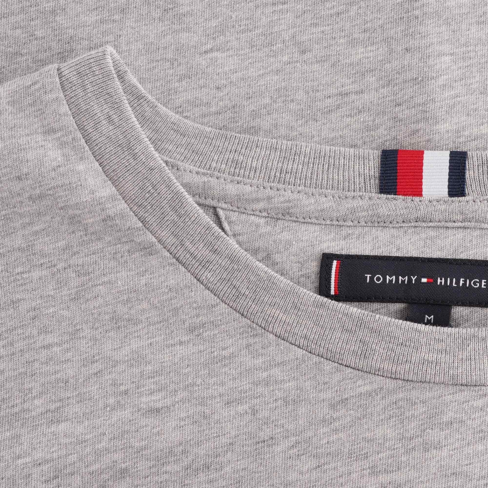 A close-up of the collar area of a grey Tommy Hilfiger t-shirt, showing the branding.