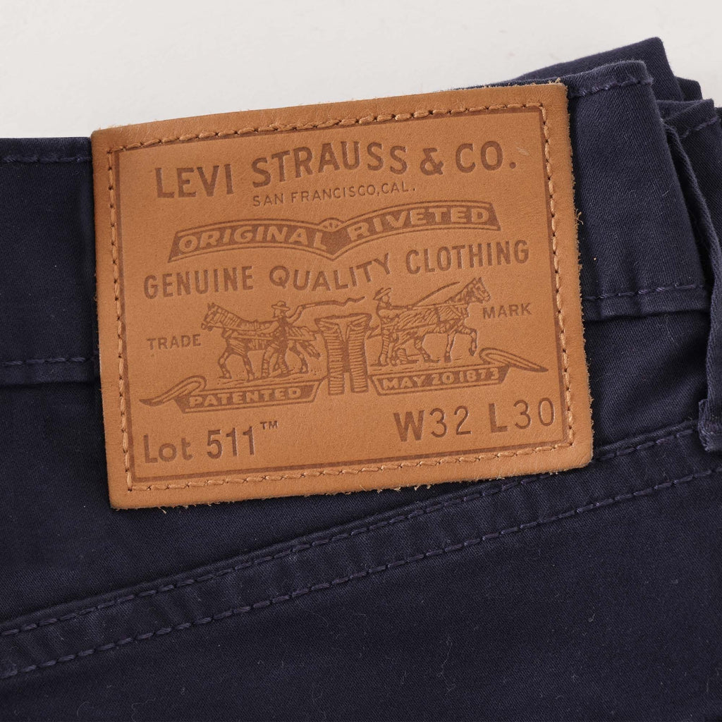 Close-up of the Levi Strauss & Co. leather patch on navy corduroy trousers.