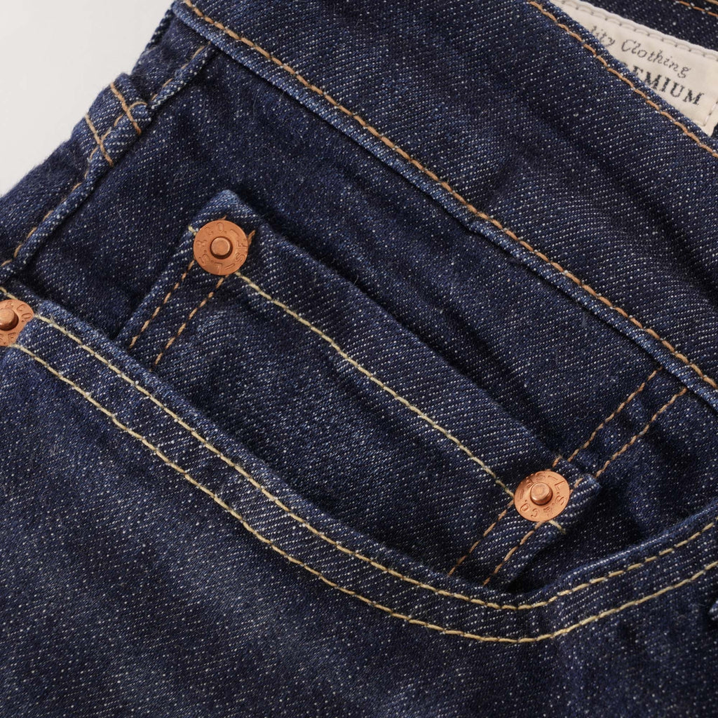 A close-up of the front pocket and copper rivets on the dark wash Levi's jeans.