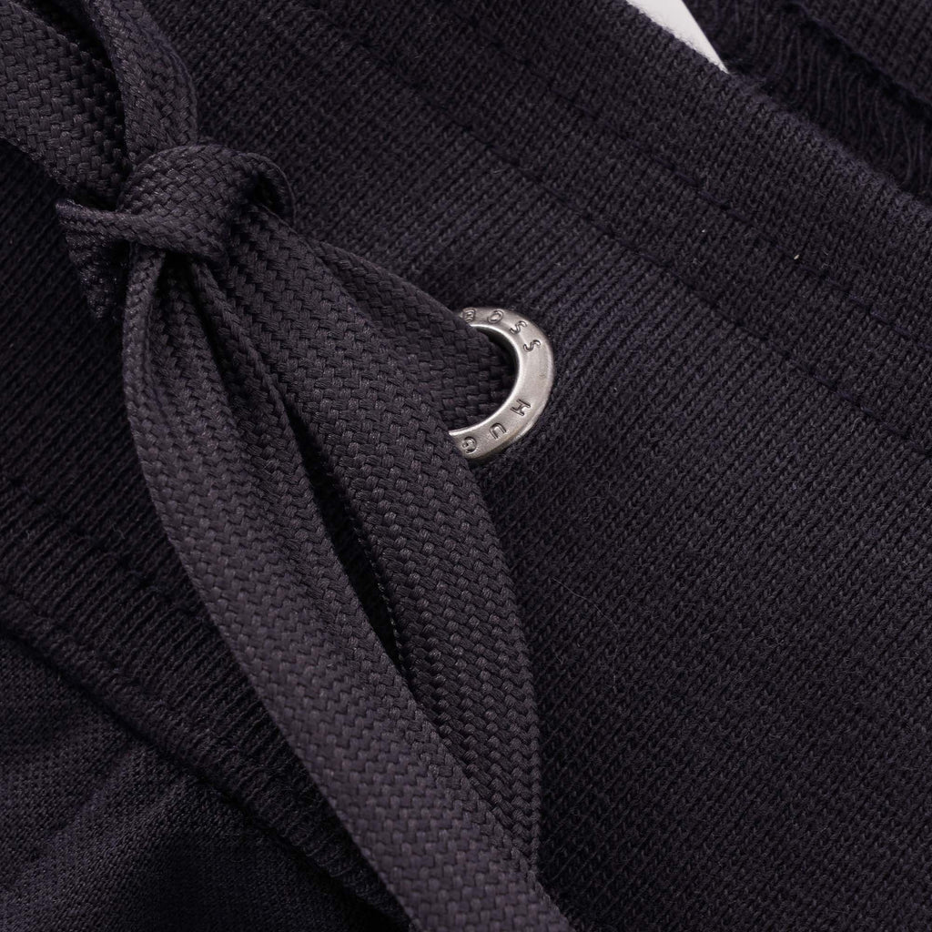 A close-up of the drawstring and metal eyelet on the BOSS tracksuit bottoms.