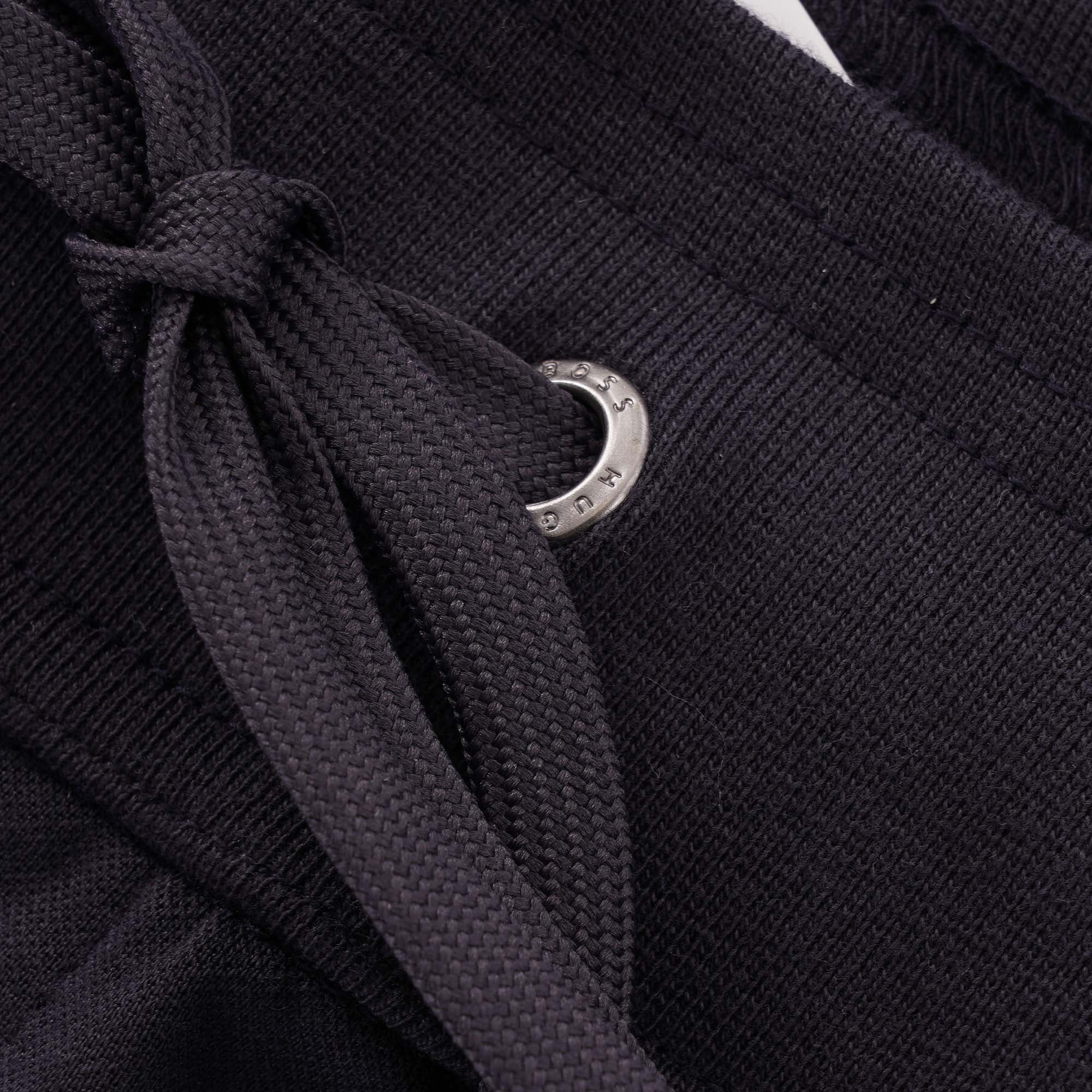 A close-up of the drawstring and metal eyelet on the BOSS tracksuit bottoms.