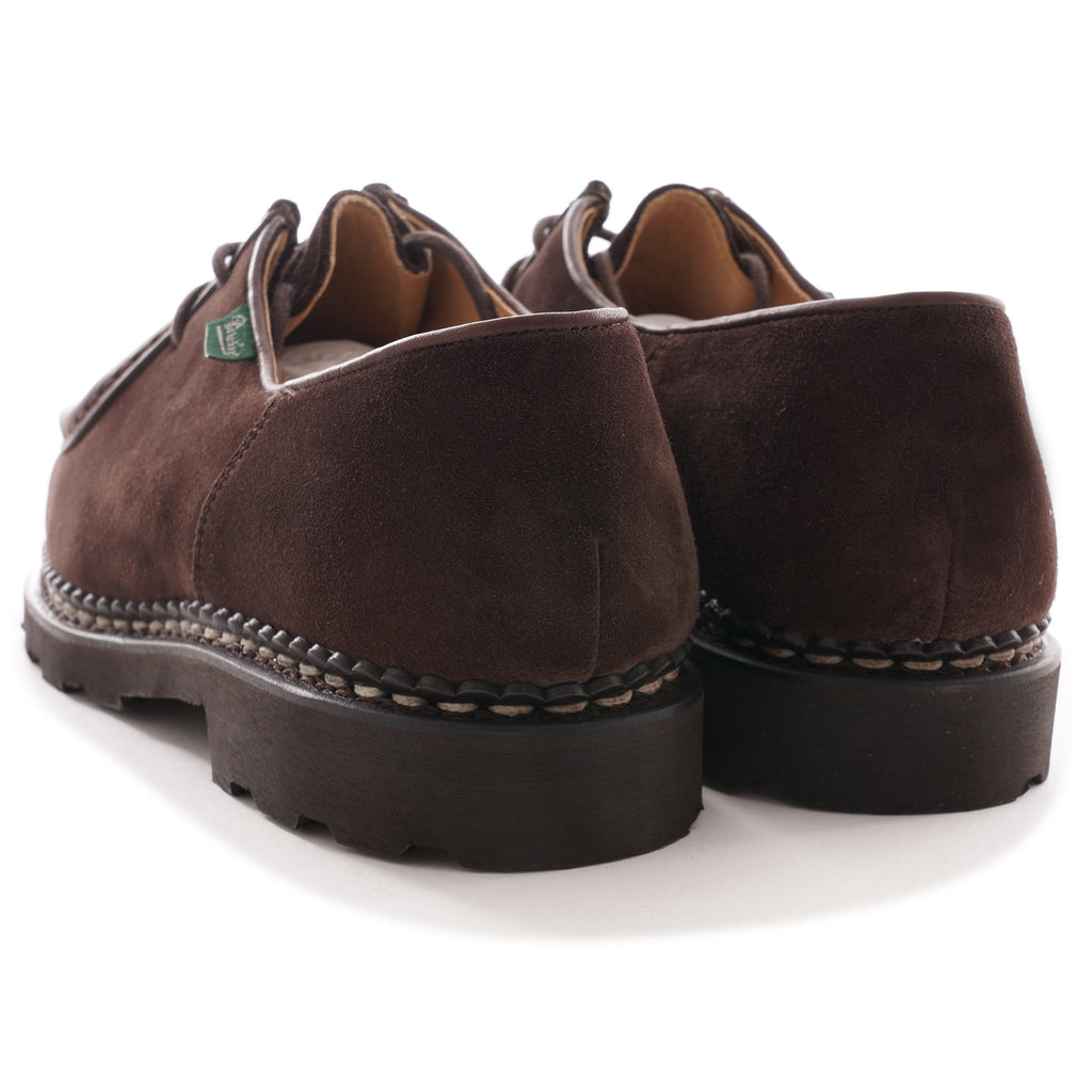 Pair of brown suede men's shoes from the back showing brand tag.