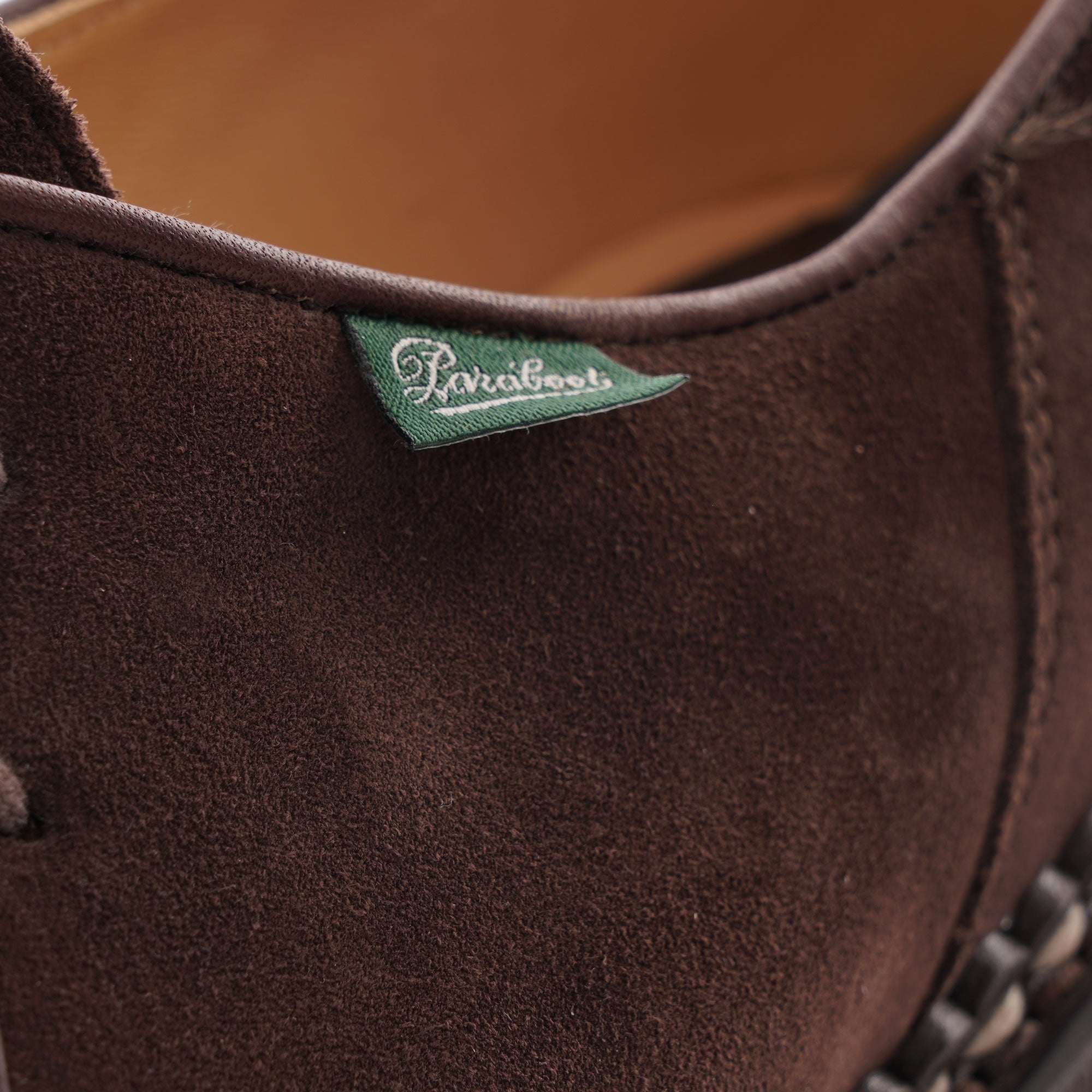 Close-up of the Paraboot brand tag on a brown suede shoe.