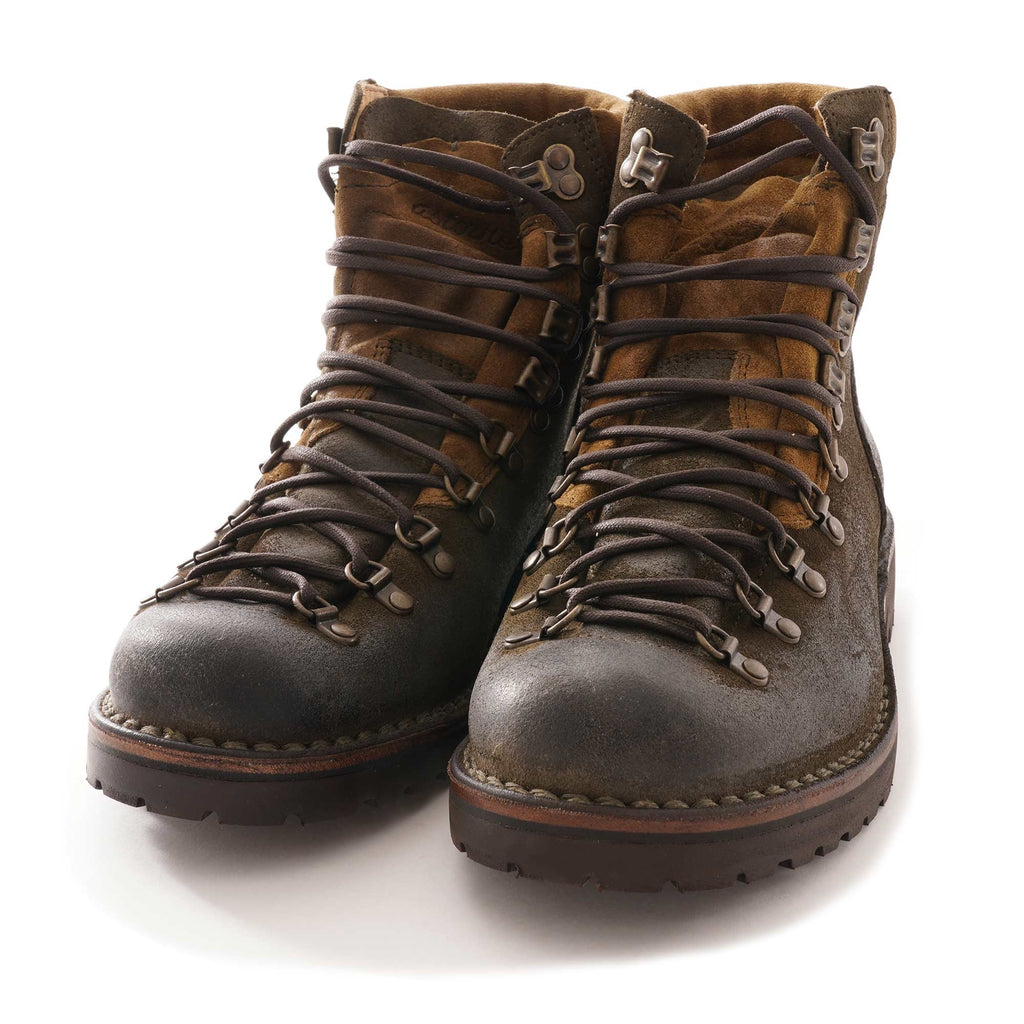 A pair of dark olive-green suede hiking boots with brown padded cuffs, front view.
