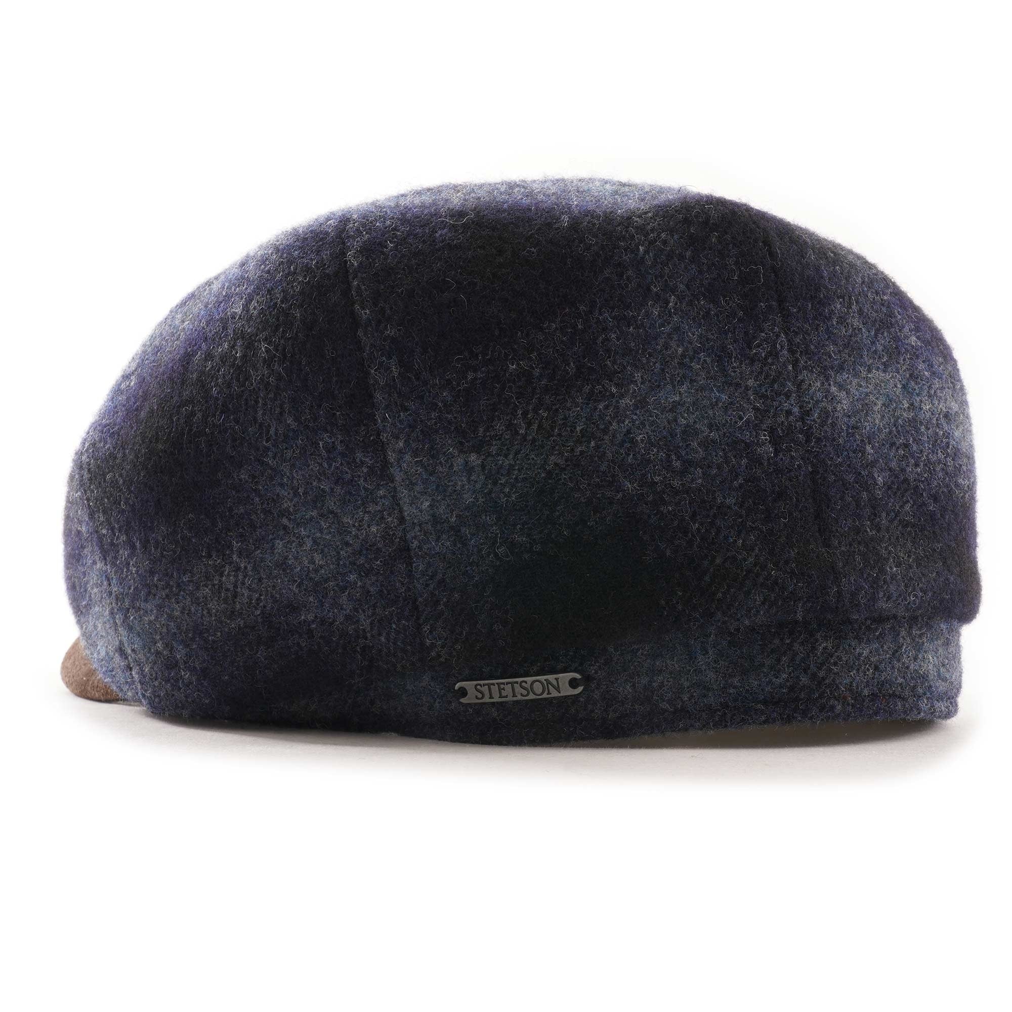 Rear view of a blue and black check flat cap with a brown suede peak.