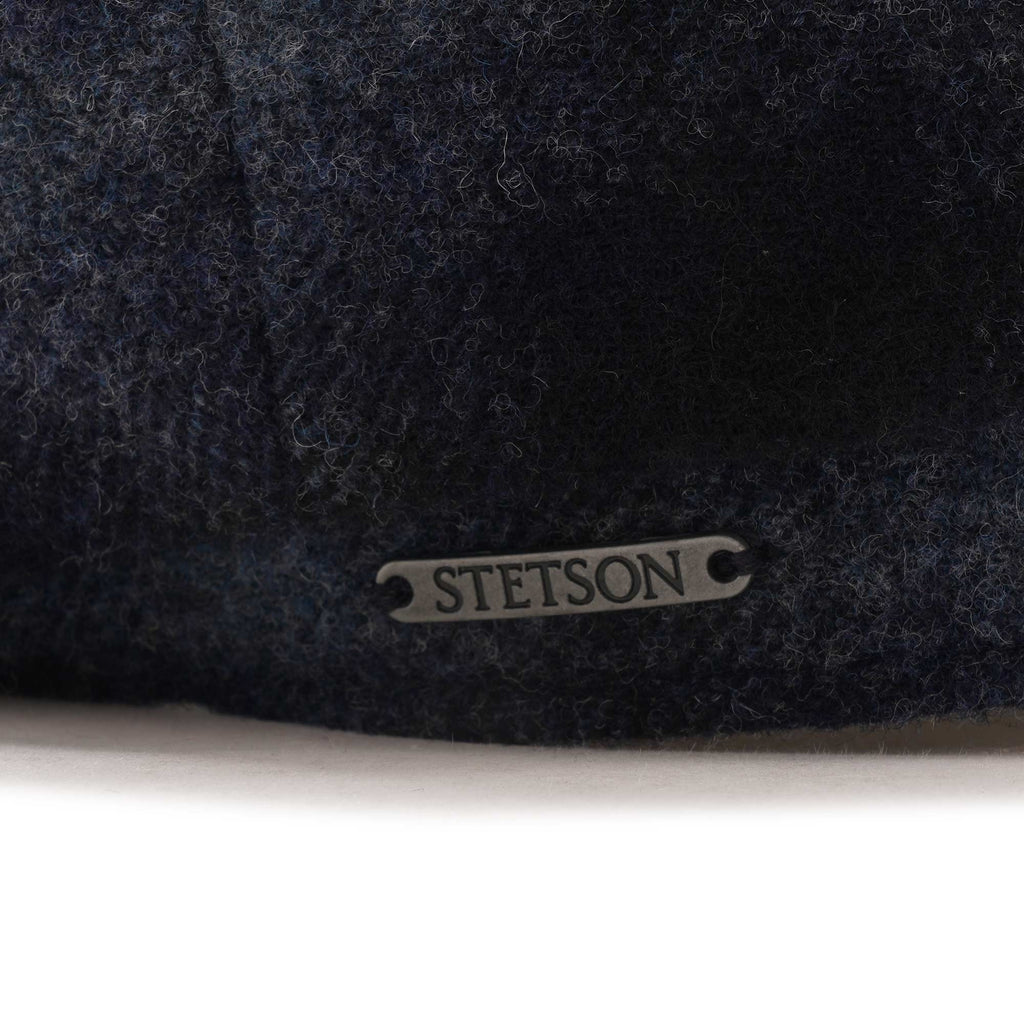 Close-up of the Stetson brand plate on the side of a flat cap.