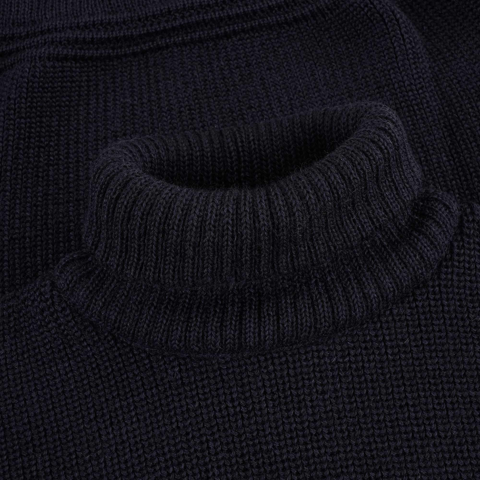 Close-up of the ribbed roll neck of a navy blue jumper.