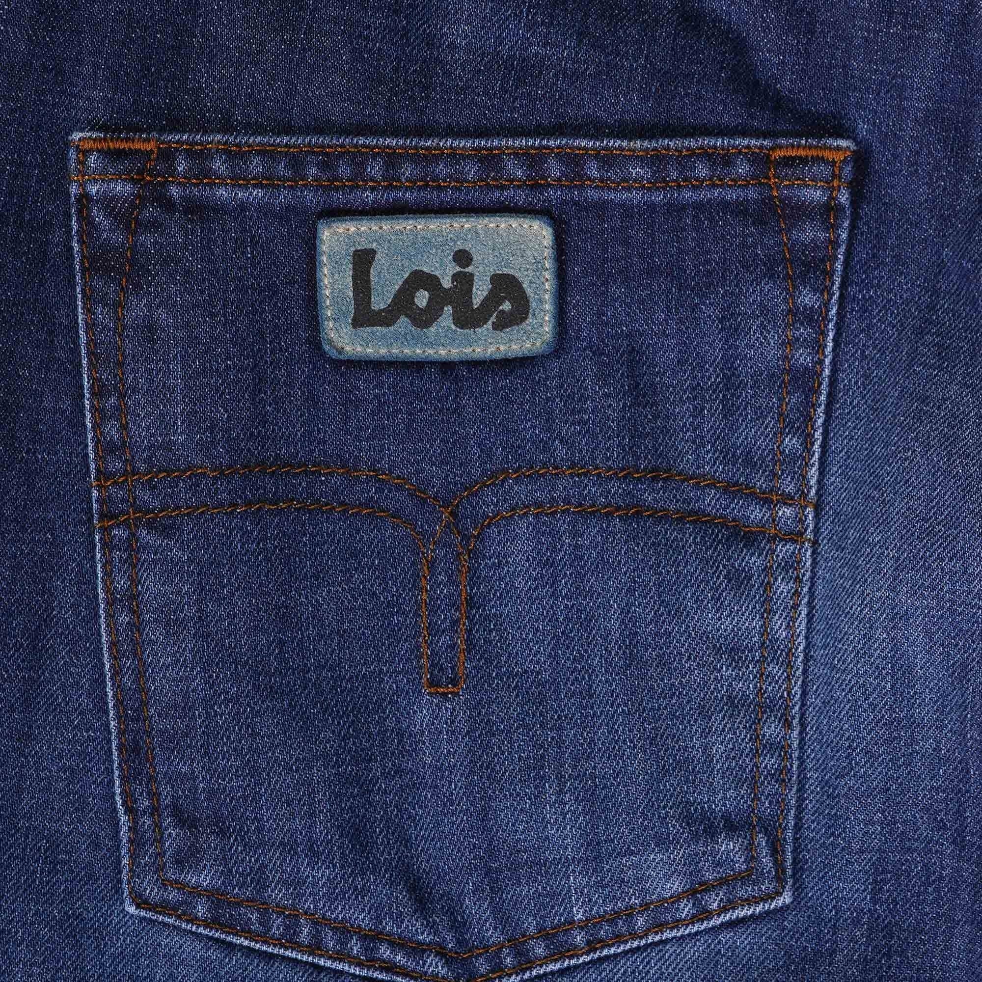 Close-up of the back pocket of dark blue Lois jeans, featuring the brand label.